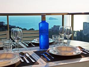 贝尼多姆Benidorm HEAVEN 29th floor的一张桌子,上面放着一瓶蓝色的葡萄酒和眼镜
