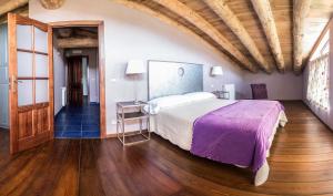 Denúy因索尔乡村民宿的一间卧室设有一张大床,铺有木地板
