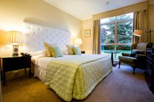 纽布里奇卡德恩酒店的卧室配有床、椅子和窗户。