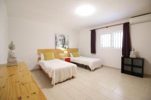 圣安东尼奥Villa Sa Barda的酒店客房设有两张床和窗户。