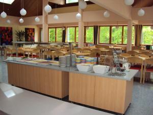 上特劳恩上特劳恩尤德酒店的学校自助餐厅,配有桌椅的柜台