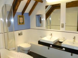 布里奇沃特老车库度假别墅的浴室设有2个水槽、卫生间和镜子。