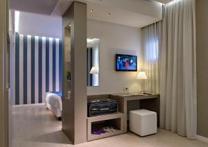 利多迪耶索罗东方&太平洋酒店的客房设有一张床、一张书桌和一面镜子