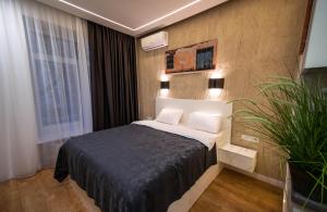 基辅Smart Apartments in Kyiv Center的一间卧室,里面装有床和植物