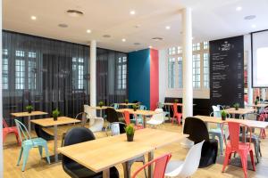 里斯本Stay Hotel Lisboa Centro Chiado的餐厅设有木桌和五颜六色的椅子