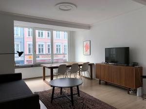 哥本哈根ApartmentInCopenhagen Apartment 1423的客厅配有桌子和平面电视。