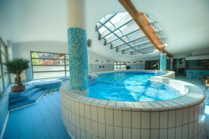 布莱德Hotel Lovec的一座带大浴缸的大楼内的大型游泳池