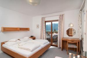 赛特朵夫苏泽恩霍夫酒店的一间卧室配有一张床、一张书桌和一个窗户。