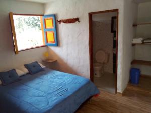 贾丁Hostal Encanto La Salada的一间卧室设有蓝色的床和窗户。