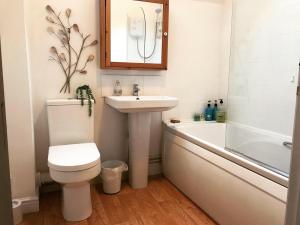 WombournClarabel's Guest House- The Nook的浴室配有卫生间、盥洗盆和浴缸。