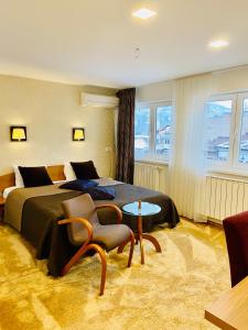 萨拉热窝Halvat Guesthouse的酒店客房带一张床、一张桌子和椅子