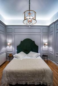 阿格里尼翁Esperia Boutique Hotel的一间卧室配有一张大床和一个吊灯。