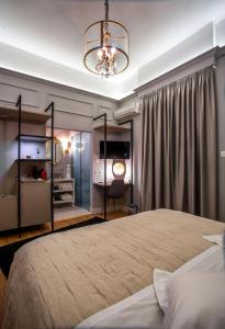 阿格里尼翁Esperia Boutique Hotel的一间卧室配有一张大床和一个吊灯。