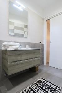 那不勒斯Napoli Vesuvio Apartments by Dimorra的浴室设有水槽、镜子和地毯。