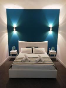 巴勒莫LOFT 99的一间卧室配有一张带蓝色墙壁的大床