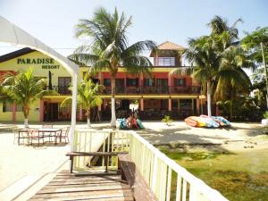 珀拉什奇亚Alan's Paradise Hotel的海滩上的一座建筑,前面有棕榈树