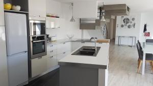 BaudTy Koukset的白色的厨房配有水槽和冰箱