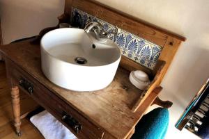 斯泰兹Dunsley Cottage的木制柜台上带白色水槽的浴室