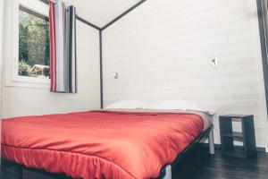 CazalsPomette 3p 4pers的一间卧室配有一张红色的床和窗户
