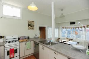 纳皮尔Puriri Downtown Villa - Napier Holiday Home的厨房配有水槽和炉灶 顶部烤箱