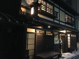 京都京ﾉ家 五条西洞院的一座在晚上有长凳的建筑