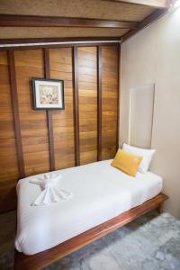 素叻100 Islands Resort & Spa的卧室配有白色的木墙床