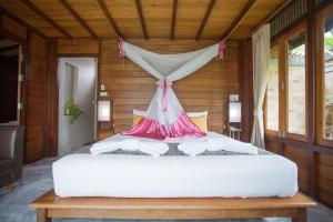 素叻100 Islands Resort & Spa的一间卧室配有一张带天蓬的白色床