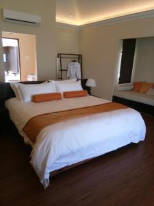 仙本那Sea Star Resort Semporna的卧室配有一张带白色床单和橙色枕头的大床。