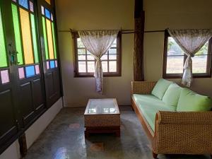 拜县Ing Doi Guest House的带沙发、桌子和窗户的客厅