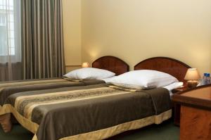 利沃夫维也纳酒店的两张睡床彼此相邻,位于一个房间里