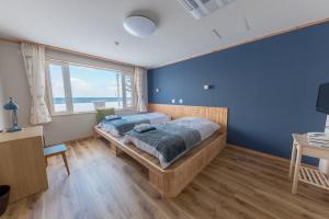 斜里町知床季风俱乐部酒店的一间卧室设有一张床和一个大窗户