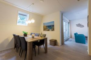 柯德科克Appartement - Kaapduinseweg 13 Dishoek M Luxe 6 personen的用餐室以及带桌椅的起居室。