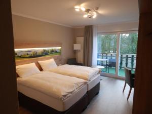 格罗森克内滕Hotel garni Haaster Krug Otte的酒店客房设有一张床和一个阳台。