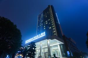 郴州郴州温德姆至尊豪廷大酒店的一座高大的建筑,晚上有灯