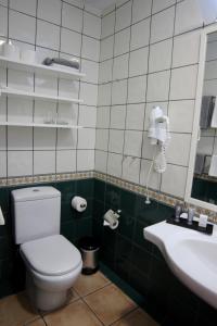 拉克鲁斯Hapimag Ferienwohnungen Puerto de la Cruz的一间带卫生间、水槽和电话的浴室