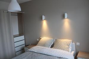勒波泰勒Appartement de 57m2 vue sur mer et plage的卧室配有一张床,墙上有两盏灯
