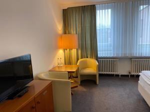 弗伦斯堡菲勒斯伯格酒店的酒店客房设有带书桌和电视的卧室。
