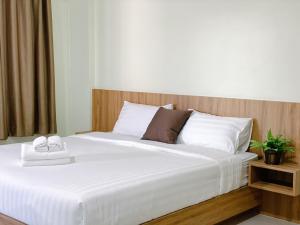 奈扬海滩Nai Yang Residence的卧室配有白色的床和木制床头板