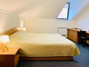 科斯特罗马科斯特罗马商务酒店的一间卧室配有一张床、一张书桌和一个窗户。