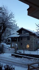 利莫内皮埃蒙特Appartamento Limone Piemonte的雪覆盖的房子,前面有栅栏
