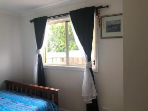 玛莎山Charlie sweet home at Mornington Peninsula的一间卧室设有一张床和一个窗口