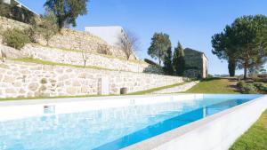 拜昂杜罗宫水疗度假村酒店的石头墙前的游泳池