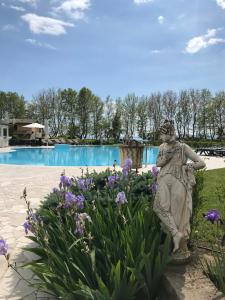 博尔塞纳Ludwig Boutique Hotel & Spa的花园中游泳池前的雕像
