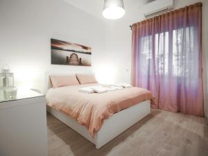 那不勒斯ChilometroZERO luxury apartment的一间卧室配有一张带粉色床单的床和一扇窗户。