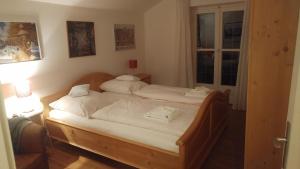 若特阿赫-埃根Ferientraum Kobellstrasse的一间卧室设有两张带白色床单的床和窗户。