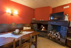 奥洛特坎布兰科酒店的客厅设有壁炉、桌子和电视
