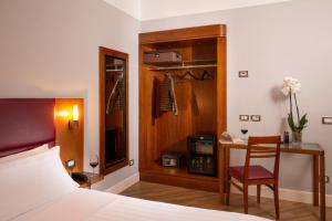 罗马贝斯特韦斯特亚斯特维德酒店的一间卧室配有一张床、一张桌子和一把椅子