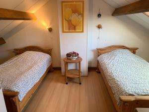 科特海讷Rustig gelegen vakantiebungalow的一间卧室配有两张床和一张鲜花桌