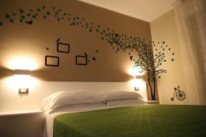 雷焦卡拉布里亚Tre Fontane的卧室配有一张绿色的床,墙上有鸟儿
