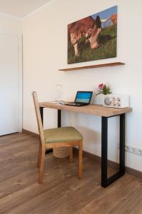 巴特维塞菲林沃浓艮特林克尔酒店的一张桌子,一张笔记本电脑和一把椅子放在房间里